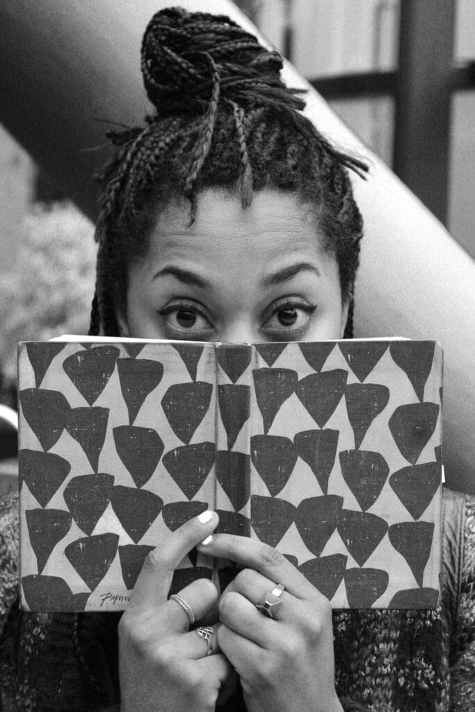 Keisha Thompson, eyes wide behind a patterned book
