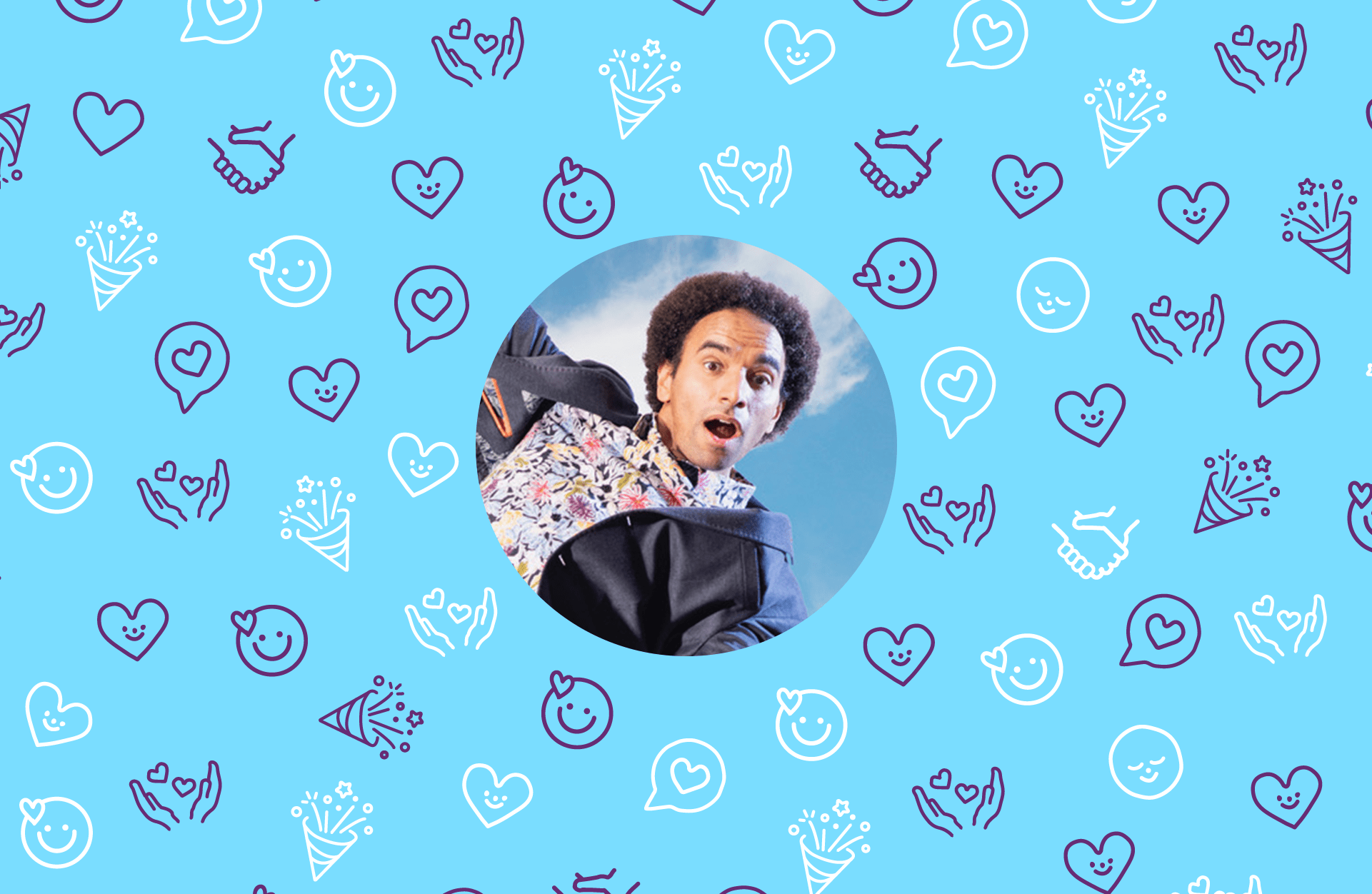 A man in a patterned shirt, and blue blazer, jumping in the air with a happy expression